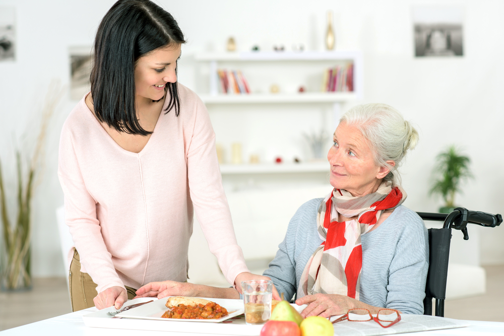 live-in-care_carer serving dinner to a patient