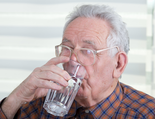 elderly man drinking a glass of water