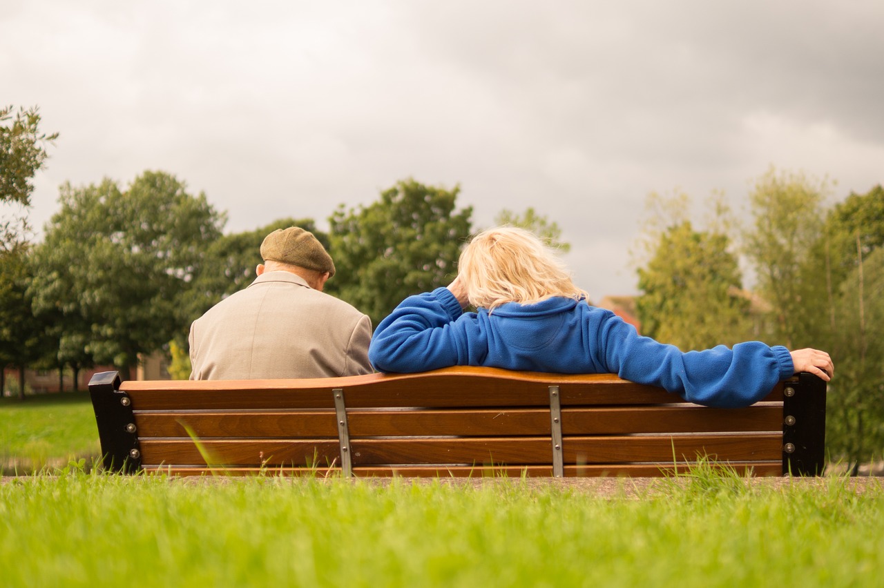 elderly people on a bench outside