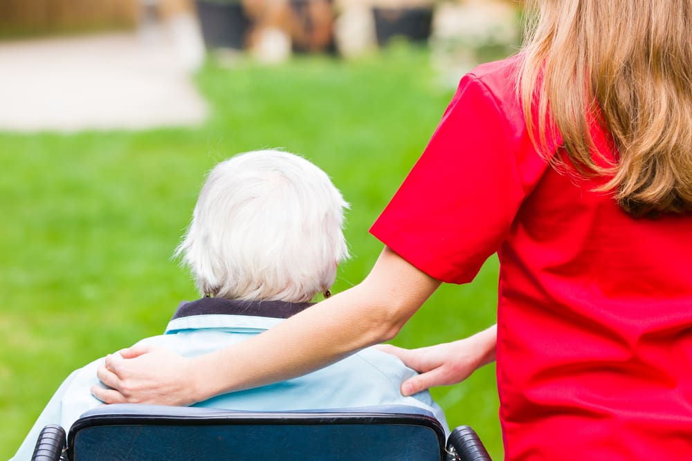 carer helping a patient in a wheelchair