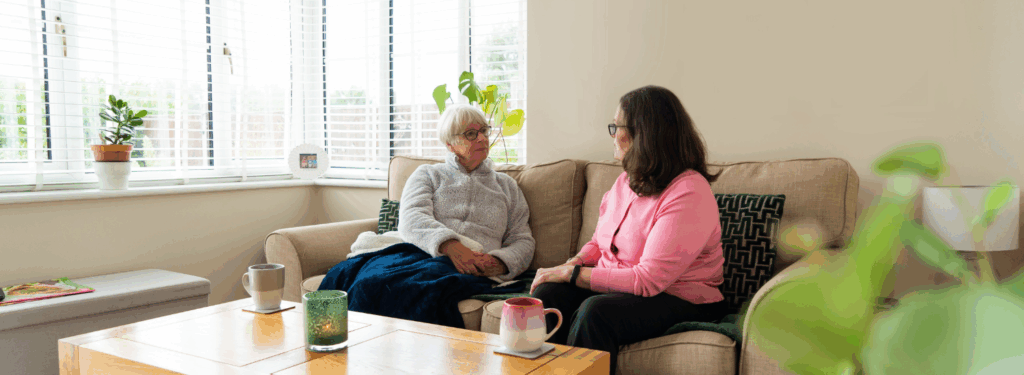 Two women have a conversation on the sofa